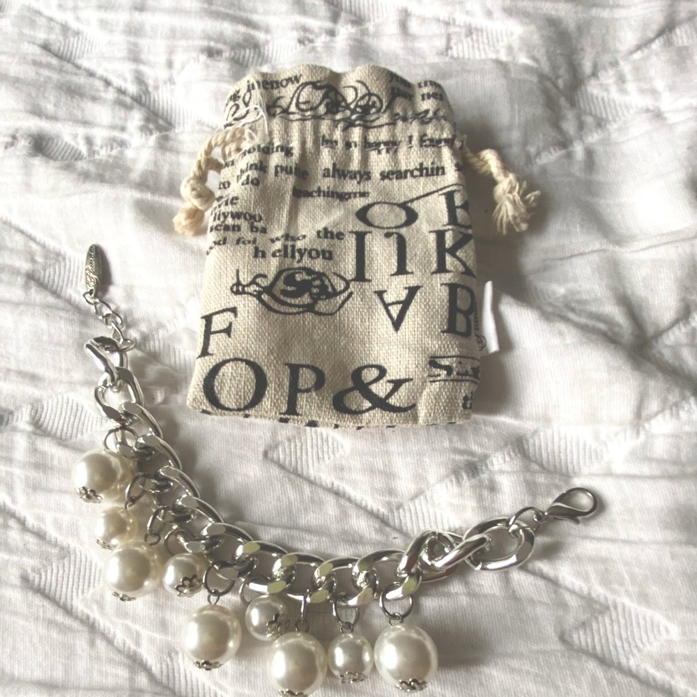 Adjustable, silver and faux drop pearl bracelet with bag.